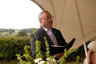 Guy Boyling officiating an outdoor wedding ceremony under a marquee