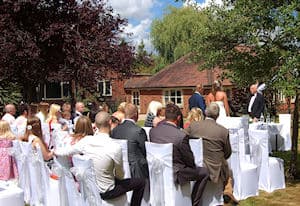 Guests watching an outdoor wedding ceremony led by Peter York